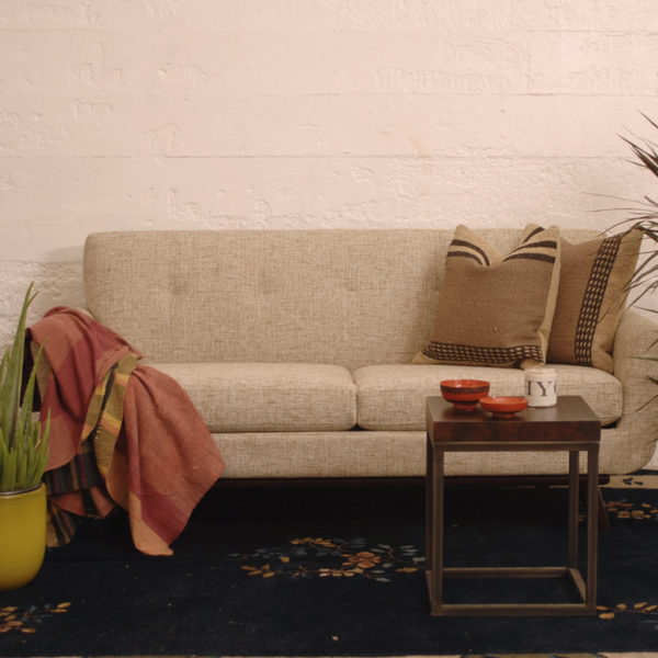 beige sofa in a living room with furniture and decor