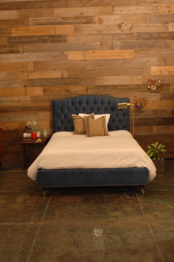 blue bed frame and a bed with w white textured blanket and decorative pillows