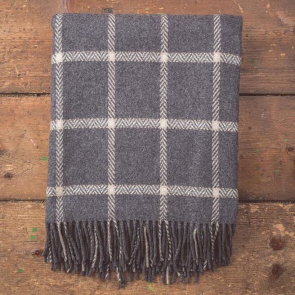grey and white windowpane patterned blanket with tassels