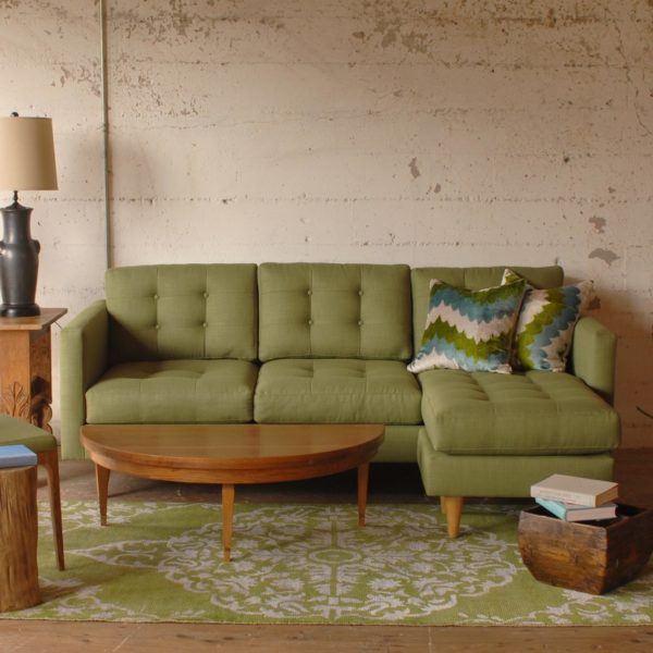 green sofa on a green rug in a living room