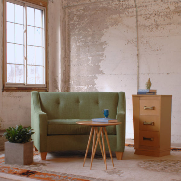 green sofa chair in a room with furniture and decor