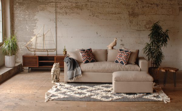 Tan sofa in living room with decor and plants