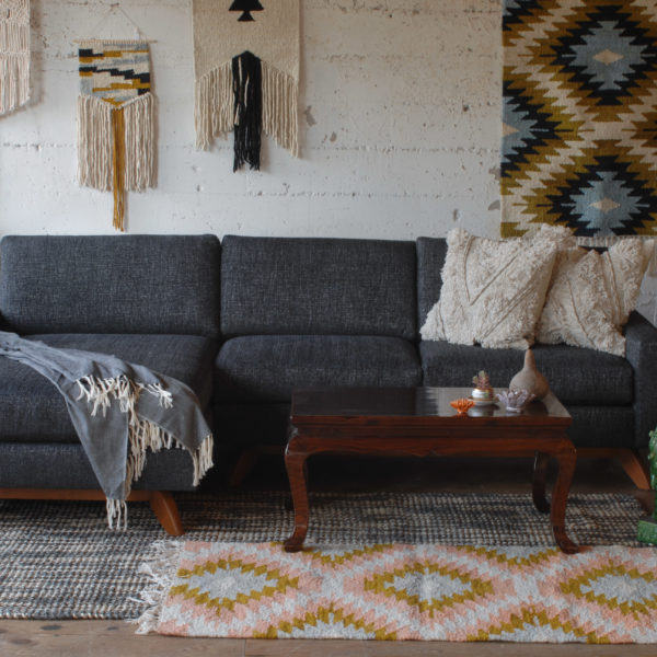 grey sofa in a living room with furniture and decor