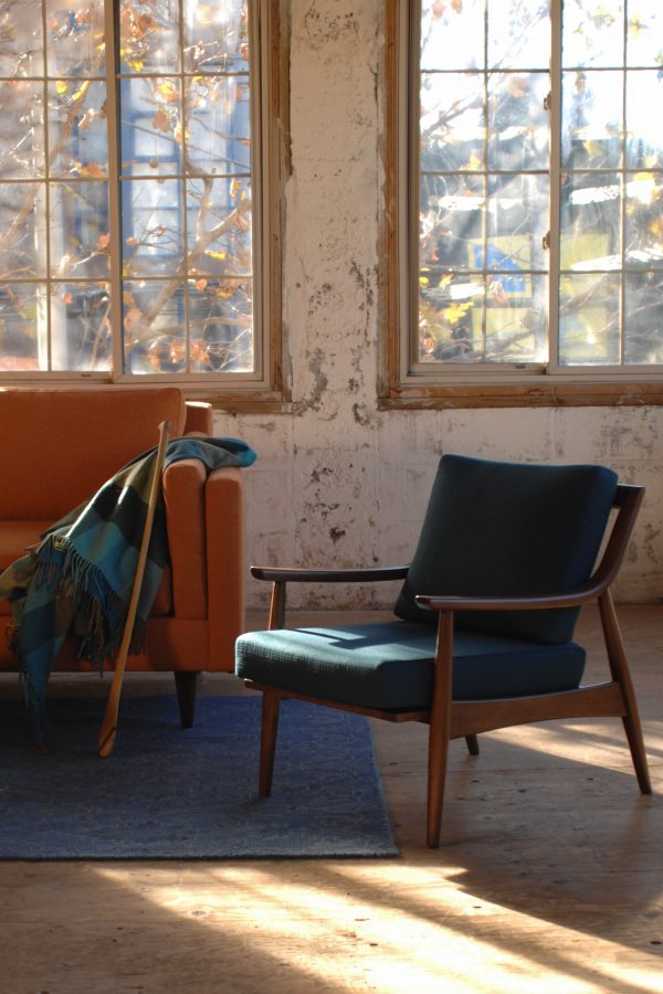 navy blue mid century modern arm chair in a living room