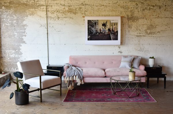pink velvet sofa in a living room with furniture and decor