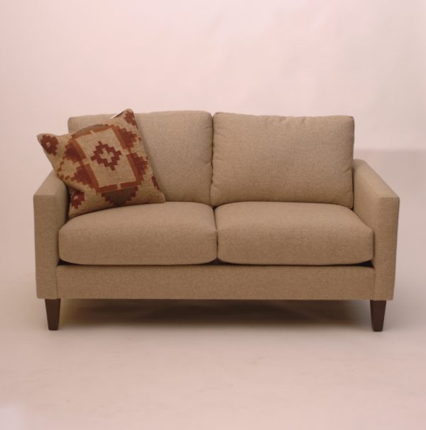 beige loveseat sofa and patterned pillow