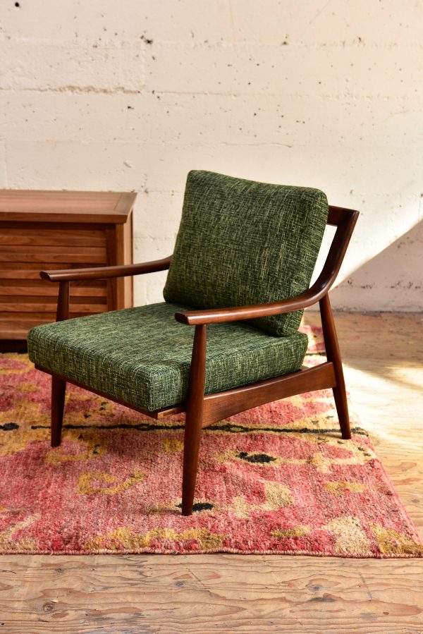 Green mid century modern style armchair in a living room