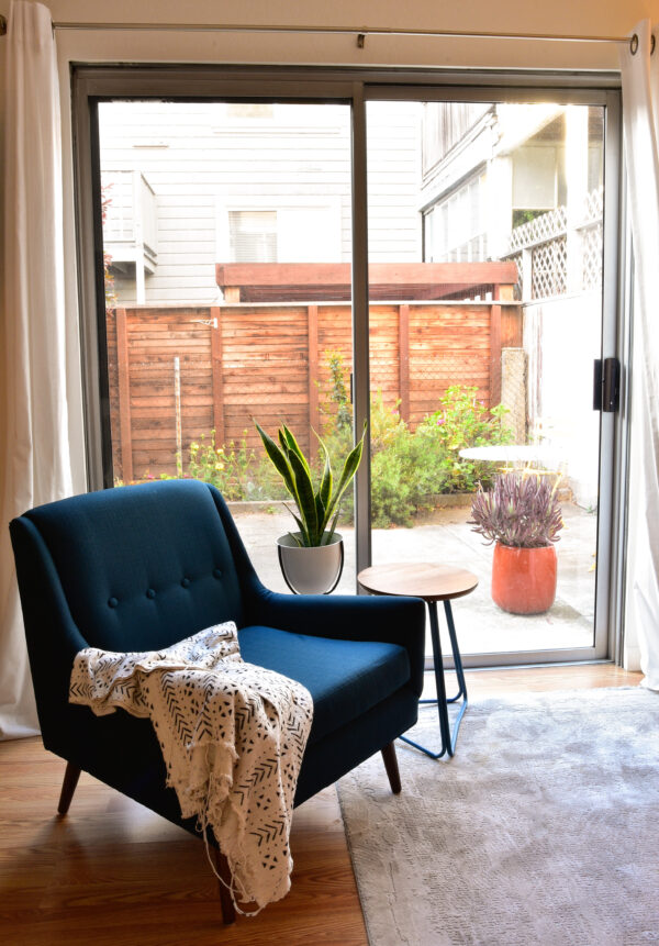 Blue accent chair in room with side table and plants