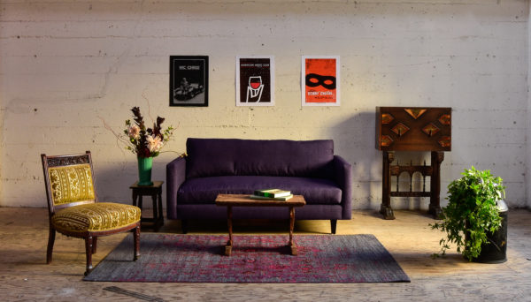 Purple sofa in living room with decor and plants