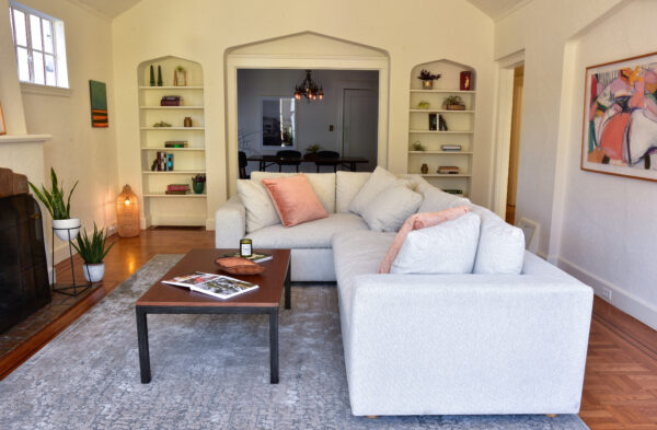 Tan sofa in living room with decor and plants