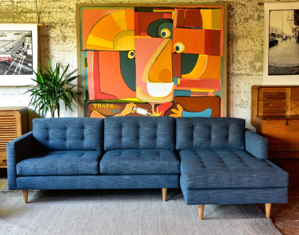 blue sofa with chaise in a living room with furniture and decor